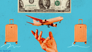A traveler checking exchange rates on a smartphone while holding foreign currency bills