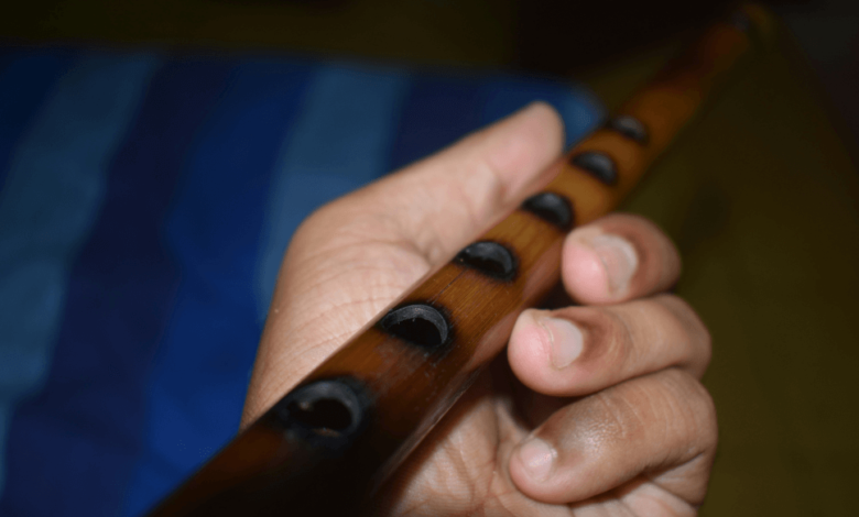 Jessica Sparvier-Wells performing 'Prairie Dusk' with her flute, embodying Indigenous resilience and prairie landscapes