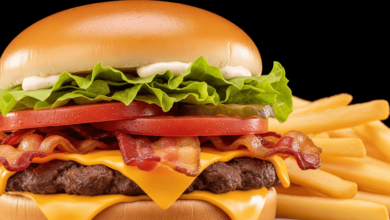 Close-up of Wendy’s Jr. Bacon Cheeseburger with crispy bacon, melted cheese, lettuce, tomato, and a toasted bun, served with fries