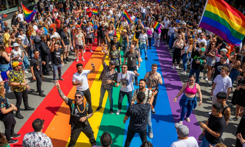 Crowds celebrating Vancouver Pride 2025 under rainbow flags and crosswalk in Davie Village