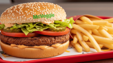 Close-up of McDonald’s McVeggie Burger with lettuce, tomato, and sauce inside a sesame seed bun, on a tray with fries.