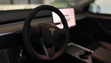 Car reviews 2025 – Tesla Model Y interior with minimalist dashboard, touchscreen, and steering wheel.