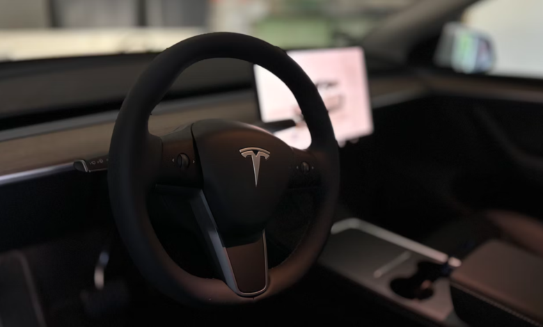 Car reviews 2025 – Tesla Model Y interior with minimalist dashboard, touchscreen, and steering wheel.