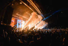 Crowd enjoying a live concert with smoke effects and dynamic lighting, capturing the energy of top upcoming events & festivals.