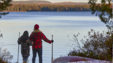 Canadian couple enjoying a peaceful lakeside staycation by a campfire—an affordable provincial vacation option in summer
