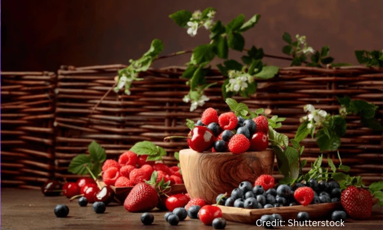 A vibrant flat-lay of mood-boosting foods including salmon, blueberries, leafy greens, yogurt, and dark chocolate arranged on a wooden table.