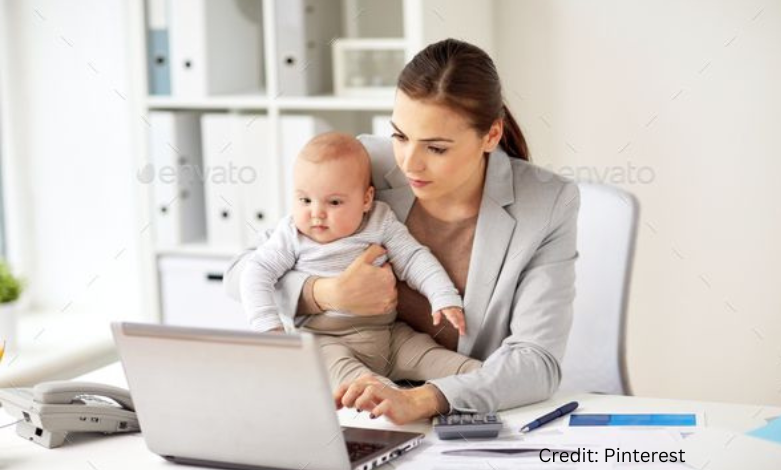 Canadian woman entrepreneur working from home on laptop with child nearby