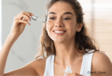 Woman applying Canadian skincare serum in a minimalist setting during a 100% Canadian beauty routine