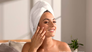 Woman applying moisturizer in a bright prairie home during August to prevent dry, sun-exposed skin