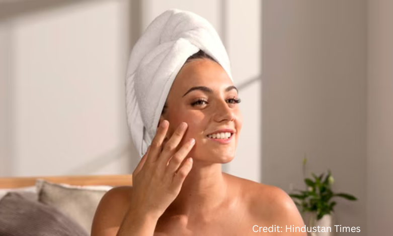 Woman applying moisturizer in a bright prairie home during August to prevent dry, sun-exposed skin