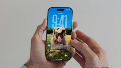 iPhone showing iOS 26 lock screen with translucent Liquid Glass widgets and redesigned notifications
