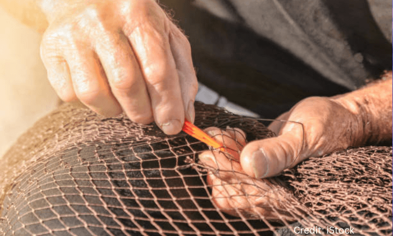A Newfoundland fisherman repairing nets by hand, symbolizing human resilience in a tech-driven world.