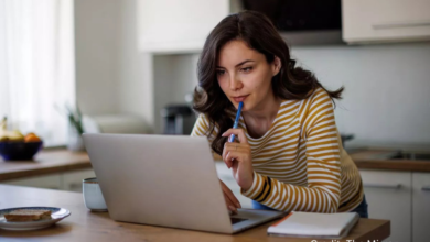 Young Surrey Millennial working late on a laptop, juggling side hustles to cover rent
