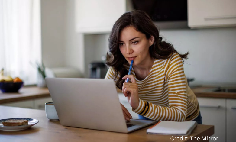 Young Surrey Millennial working late on a laptop, juggling side hustles to cover rent
