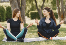 Two women practicing outdoor yoga in a park during Abbotsford’s Spring Health & Wellness Events