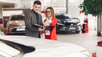 Used car buyer comparing vehicle prices at a dealership in Canada