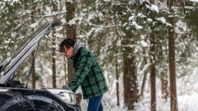 Driver checking a car in snowy winter conditions