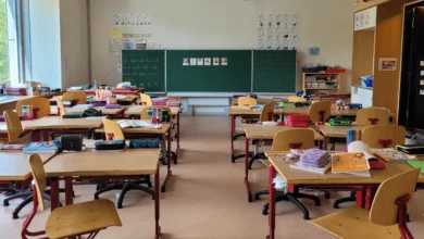 Students facing the impact of the crisis in Surrey’s education system with empty classrooms and cut program signs.