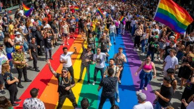 Crowds celebrating Vancouver Pride 2025 under rainbow flags and crosswalk in Davie Village
