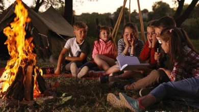 Children at a summer camp in Saskatchewan sitting around a campfire without phones, laughing and bonding in a natural setting