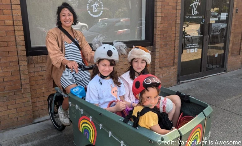 A parent rides an electric cargo bike with two children through a residential street in Vancouver