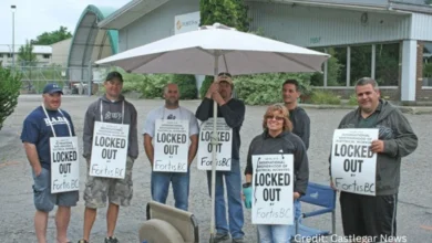 IBEW Local 213 FortisBC workers holding strike signs outside facility during contract dispute