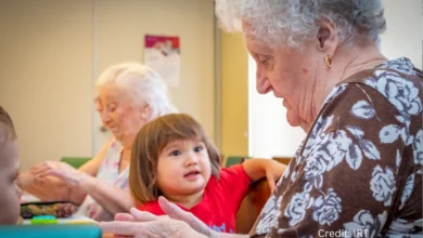 Young child and senior woman painting together at intergenerational playschool in Surrey