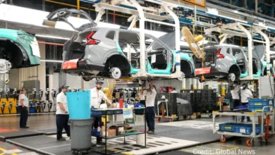 Canadian auto factory assembly line with workers facing uncertainty from new tariffs