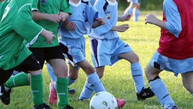 Canadian children playing soccer in a park while their phones and tablets are set aside