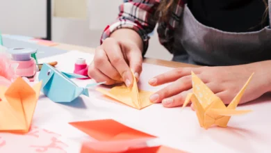 Unfold Your Potential: Origami Arts for Wellness at UFV workshop with student folding colorful origami cranes for mindfulness