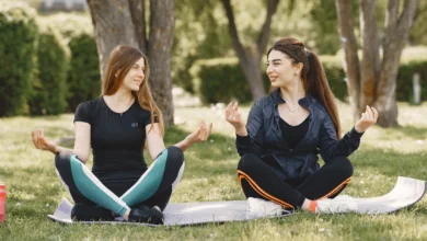 Two women practicing outdoor yoga in a park during Abbotsford’s Spring Health & Wellness Events