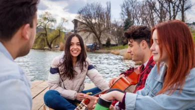 Friends enjoying music and conversation by the water as part of Vancouver community-led experiences in a public outdoor space.