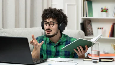 A young professional attending Free Online Skill Courses on a laptop while studying with headphones and notes at home.