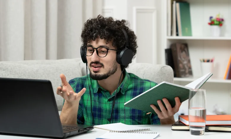 A young professional attending Free Online Skill Courses on a laptop while studying with headphones and notes at home.