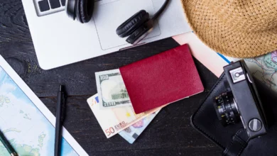 Travel essentials with passport, cash, and camera representing budget travel in Canada planning and cost-saving travel preparation