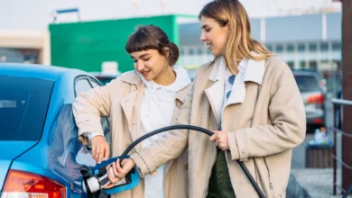 Two people charging an electric car at a public station, showing EV charging cost in Canada and real-life charging usage