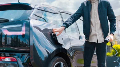 Why Electric Cars Are Not the Future concept showing a driver charging an electric vehicle