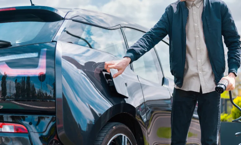 Why Electric Cars Are Not the Future concept showing a driver charging an electric vehicle